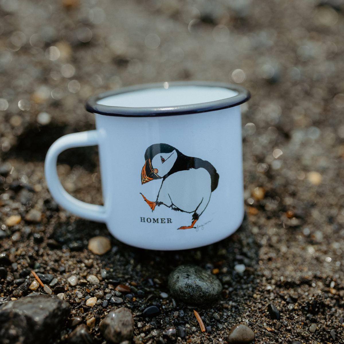 Puffin drawn by artist Tracy Hansen with Homer below, this is a 12oz white mug with black writing and a black ring around the top of mug. Great for camping and hiking. 